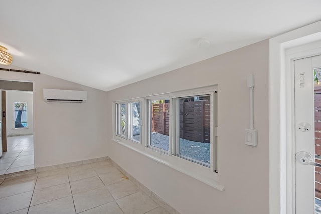 spare room featuring light tile patterned floors, vaulted ceiling, baseboards, and an AC wall unit