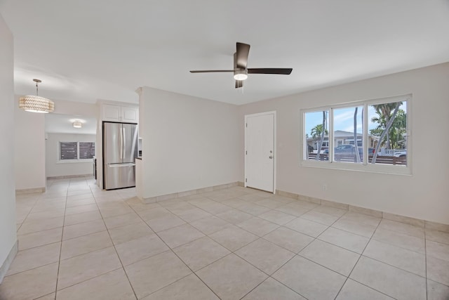 unfurnished living room featuring light tile patterned floors, baseboards, and ceiling fan
