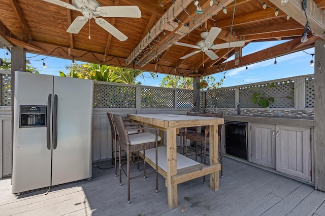wooden deck with outdoor dining area and ceiling fan