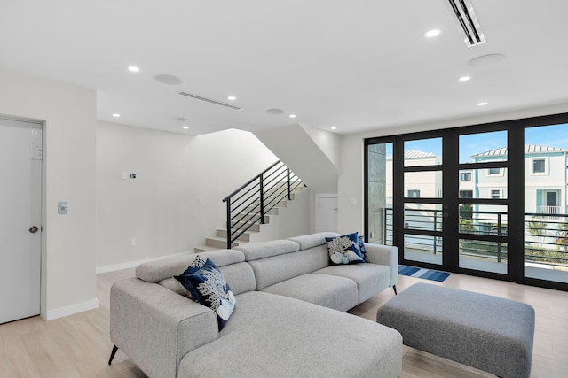 living room with light wood-style floors, recessed lighting, stairs, and visible vents