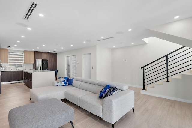 living room featuring visible vents, recessed lighting, stairway, and light wood-type flooring