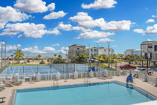 view of swimming pool featuring tennis court