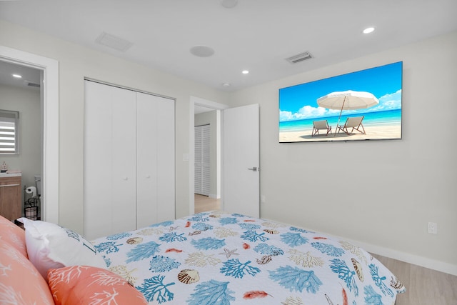 bedroom featuring recessed lighting, visible vents, wood finished floors, and a closet