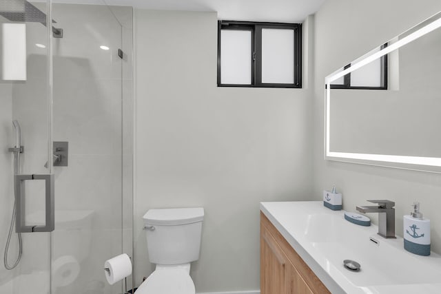 bathroom featuring a shower with door, vanity, and toilet