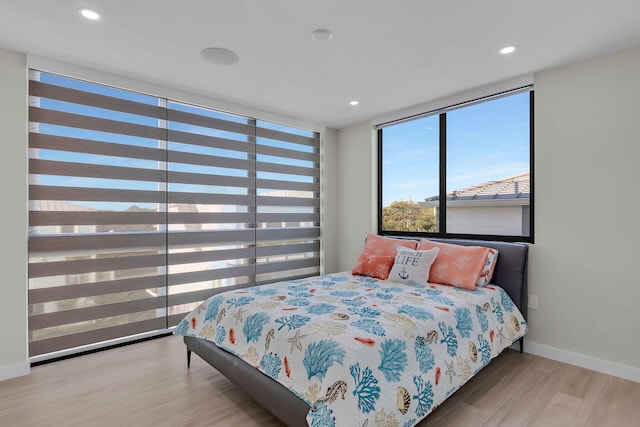 bedroom with baseboards, recessed lighting, and wood finished floors