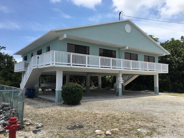 18 Palm Dr, Key Largo, FL 33037 - view of front facade featuring a carport, driveway, stairs, and stucco siding