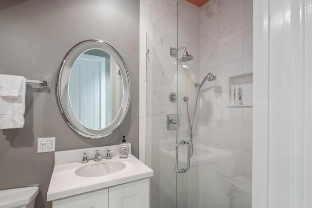 bathroom with vanity, toilet, and a shower with shower door