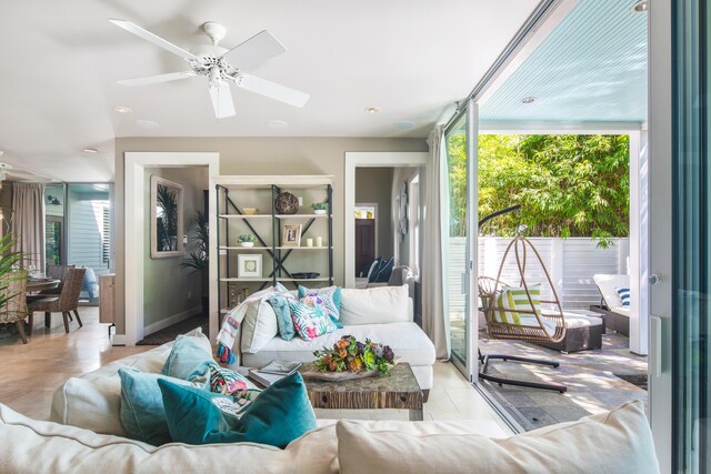 living room with ceiling fan and a wall of windows