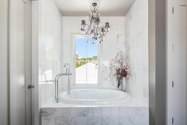 bathroom featuring a relaxing tiled tub, an inviting chandelier, and tile walls