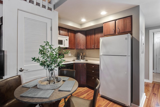 kitchen featuring white appliances, sink, and light wood-type flooring