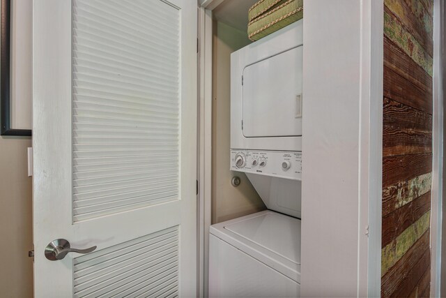 clothes washing area with stacked washer / dryer