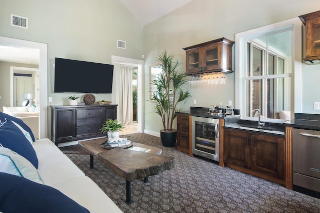 living room featuring beverage cooler, high vaulted ceiling, and wet bar