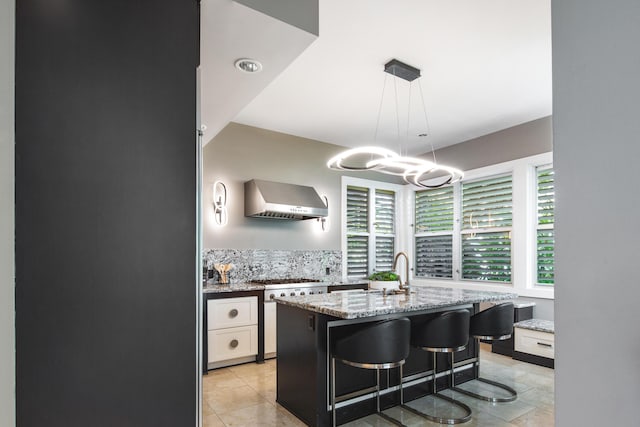 400 Aronovitz Ln, Key West, FL 33040 - kitchen featuring white cabinets, wall chimney exhaust hood, light stone countertops, and a sink