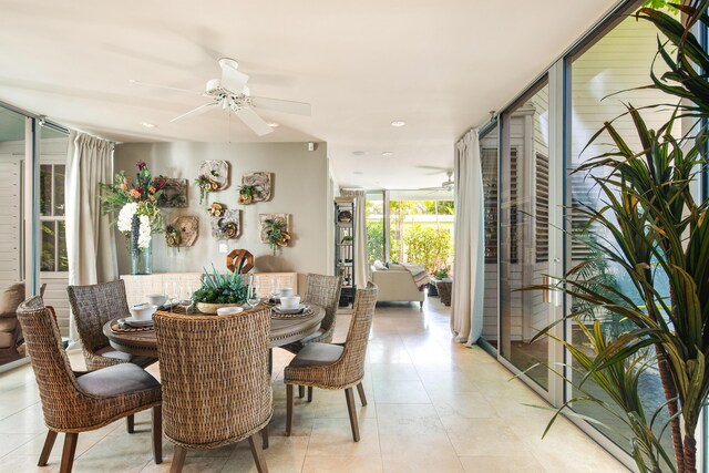 tiled dining space featuring floor to ceiling windows and ceiling fan