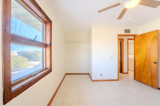 unfurnished room with light tile patterned floors, washer / dryer, and ceiling fan