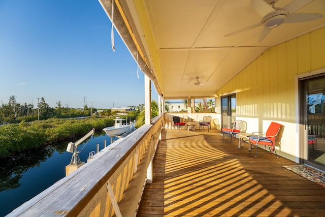 balcony featuring ceiling fan and a water view