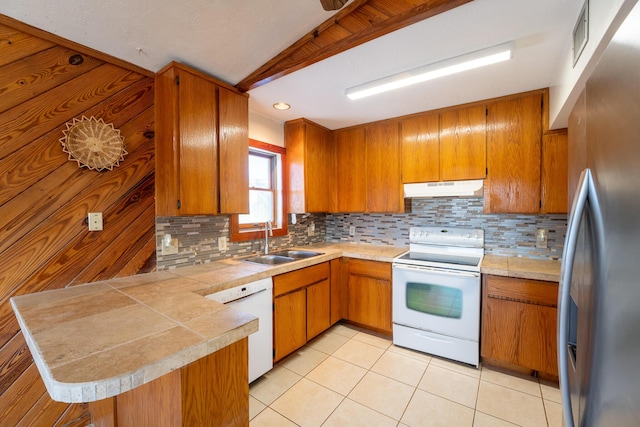 kitchen with sink, white appliances, kitchen peninsula, and decorative backsplash