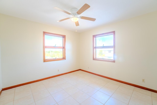 tiled spare room featuring plenty of natural light and ceiling fan