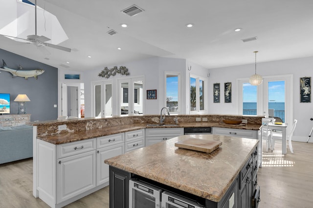 23 S Kyle Way, Marathon, FL 33050 - kitchen with pendant lighting, sink, white cabinetry, a water view, and a kitchen island