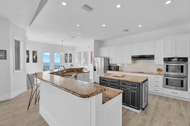 23 S Kyle Way, Marathon, FL 33050 - kitchen with a spacious island, white cabinets, black appliances, and pendant lighting