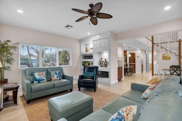 living room with ceiling fan and light wood-type flooring