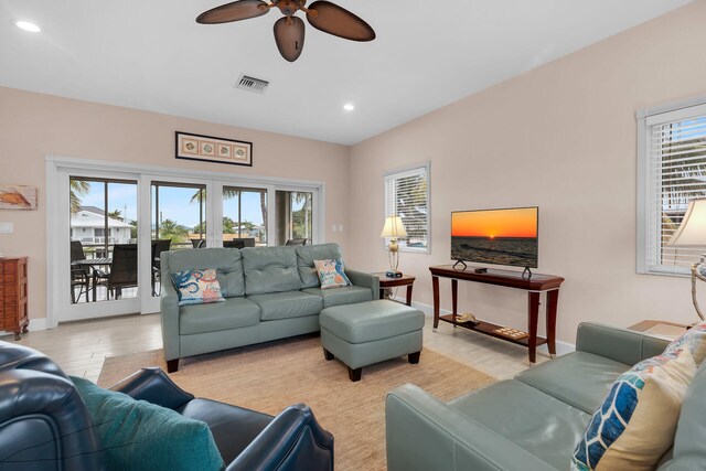 living room with light hardwood / wood-style flooring and ceiling fan