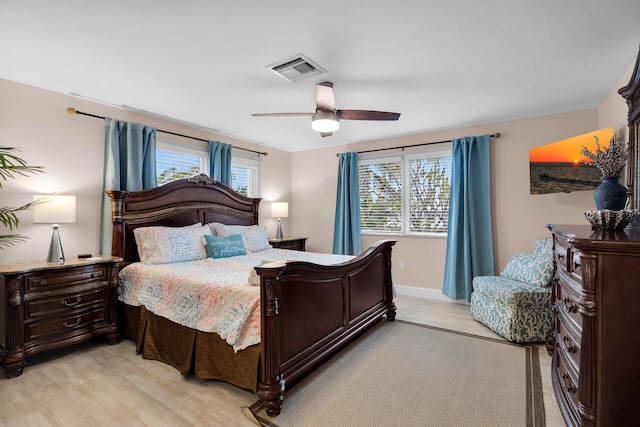 bedroom featuring multiple windows, light hardwood / wood-style floors, and ceiling fan