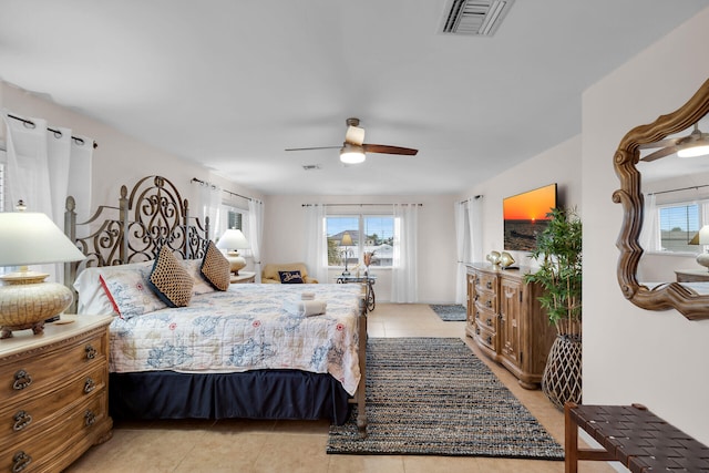 tiled bedroom featuring multiple windows and ceiling fan