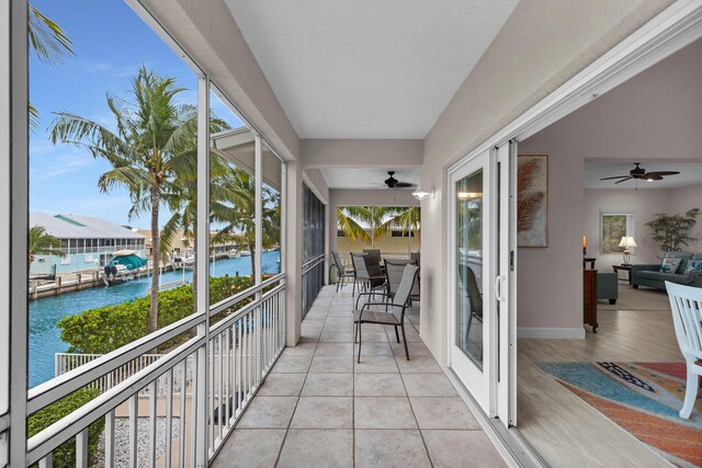 balcony with a water view and ceiling fan