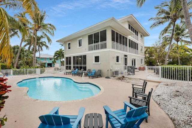 view of pool with a sunroom and a patio