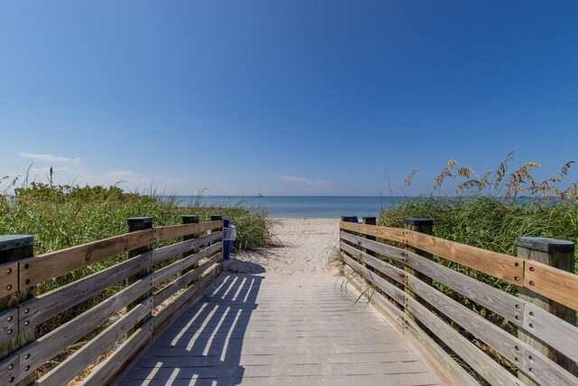 view of property's community with a water view and a view of the beach