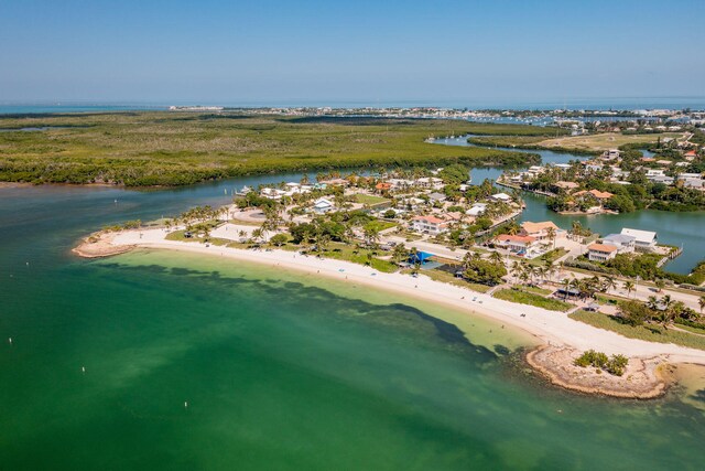 birds eye view of property with a water view and a beach view