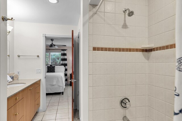 bathroom with tile patterned flooring, vanity, tiled shower / bath combo, and ceiling fan