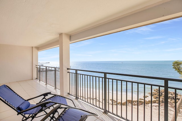 balcony with a water view and a beach view