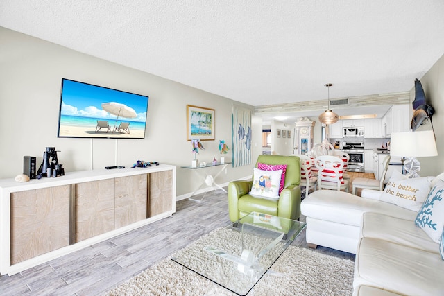 living room featuring a textured ceiling and light wood-type flooring