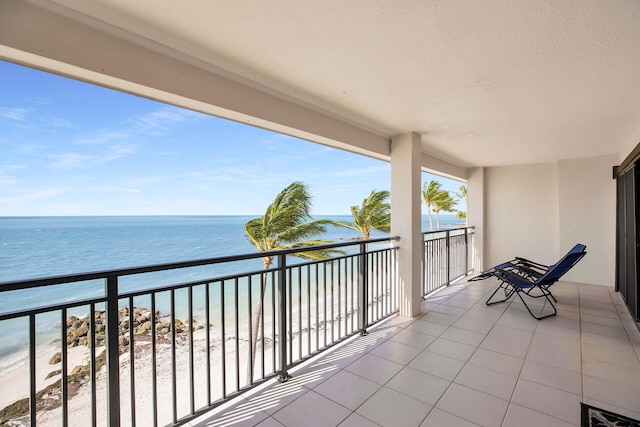 balcony featuring a water view and a beach view