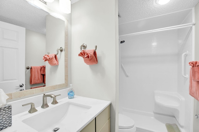 bathroom featuring walk in shower, vanity, toilet, and a textured ceiling