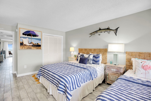 bedroom featuring a textured ceiling, a closet, and light wood-type flooring