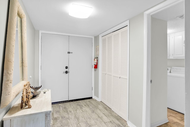 interior space with washer / dryer and light hardwood / wood-style floors