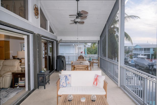 sunroom featuring lofted ceiling and ceiling fan