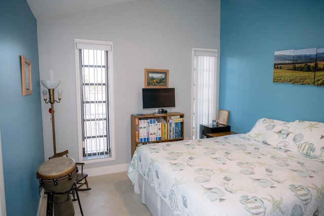 bedroom with vaulted ceiling and baseboards