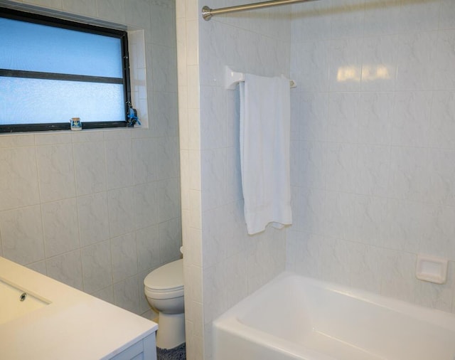 bathroom featuring tile walls, shower / bathing tub combination, vanity, and toilet