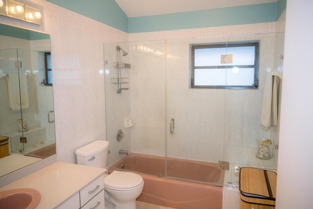 full bathroom featuring tile walls, combined bath / shower with glass door, vanity, and toilet