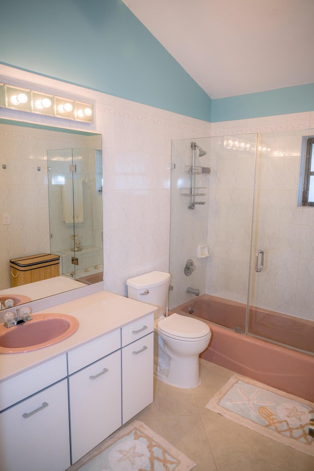 full bath with tile walls, lofted ceiling, toilet, combined bath / shower with glass door, and vanity
