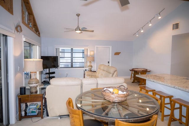 living area with lofted ceiling, ceiling fan, visible vents, and track lighting