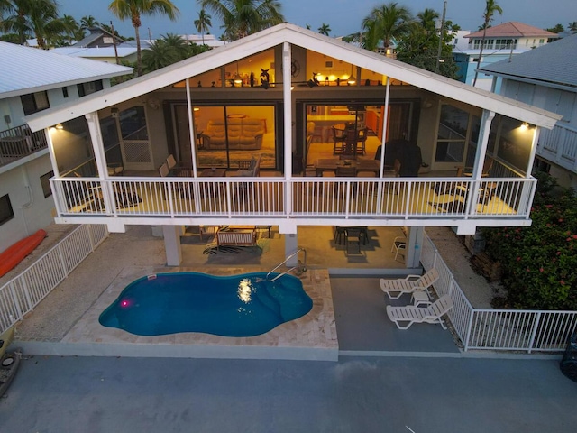 exterior space with a patio, a sunroom, fence, a balcony, and an outdoor pool