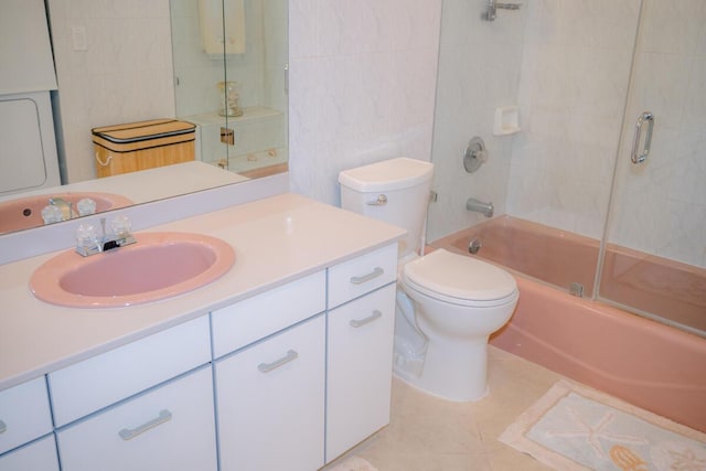full bath featuring bath / shower combo with glass door, toilet, tile patterned floors, vanity, and tile walls
