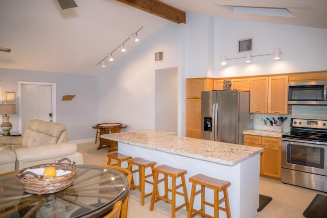 kitchen featuring appliances with stainless steel finishes, visible vents, and a breakfast bar area