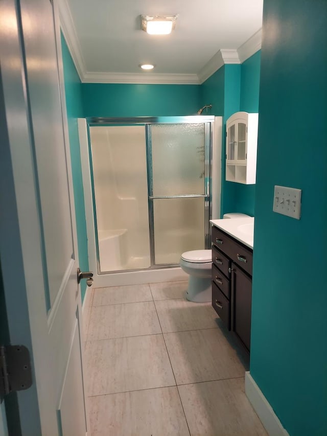 bathroom with tile patterned floors, toilet, a shower with shower door, crown molding, and vanity