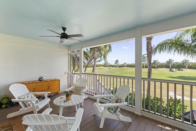 deck featuring a ceiling fan and a lawn